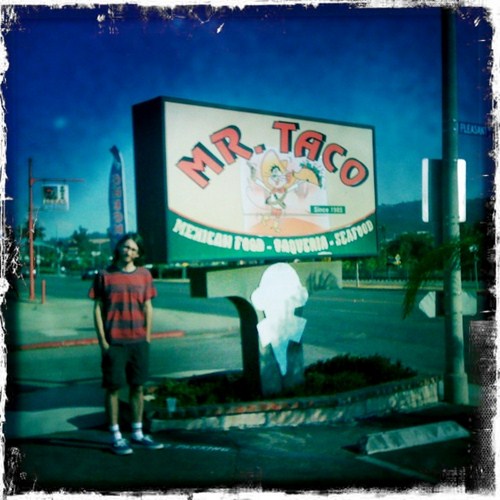Randy stands beside the Mr. Taco sign in San Marcos, California.