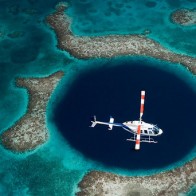 A helicopter flying over Blue Hole Belize.
