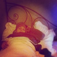 A woman laying in bed who has food poisoning