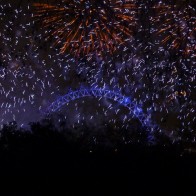 Fireworks exploding over the London Eye ferris wheel in London, England on New Year's Eve.